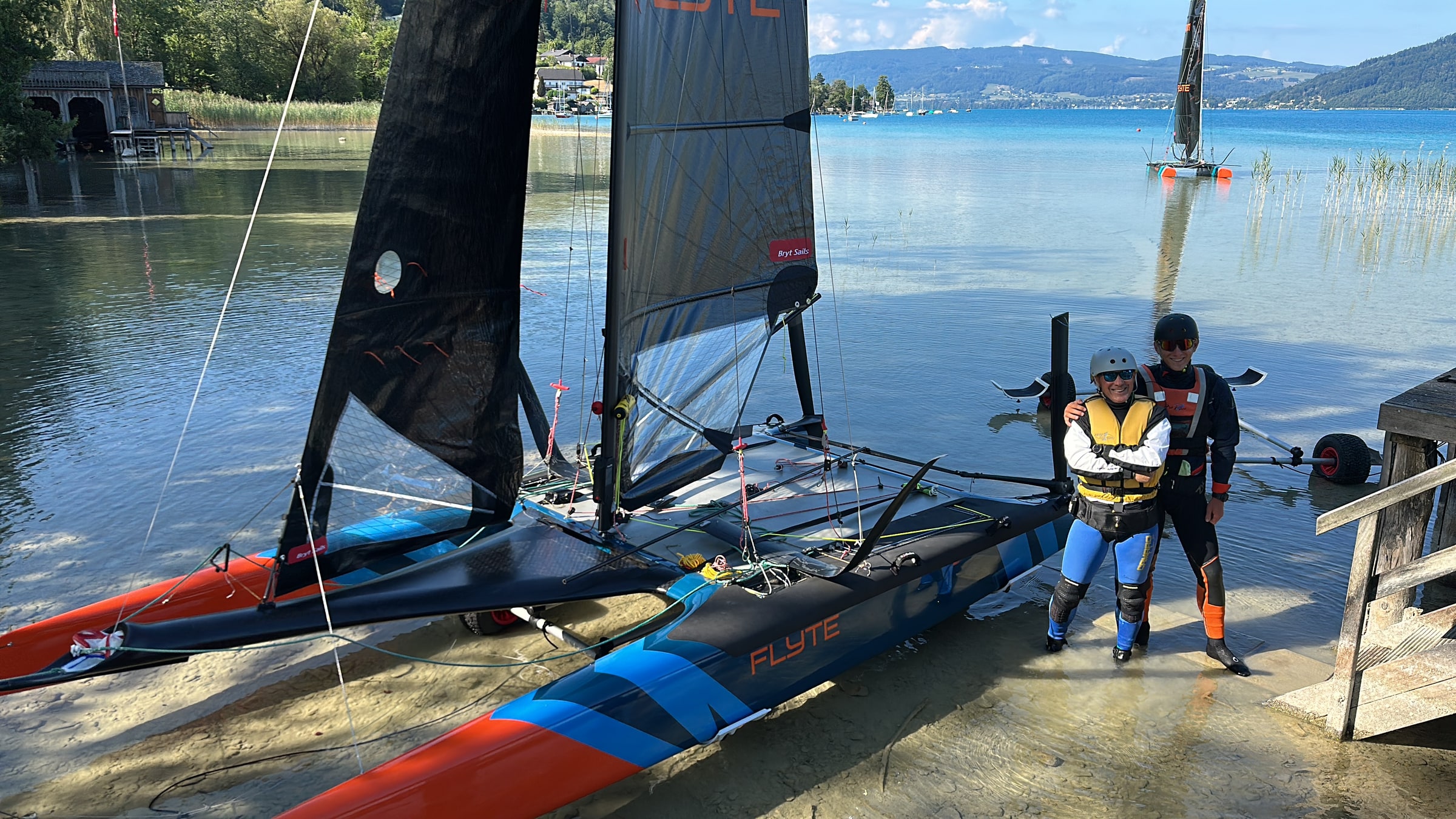 Two Flyte catamarans sailing side by side with crews on trapeze